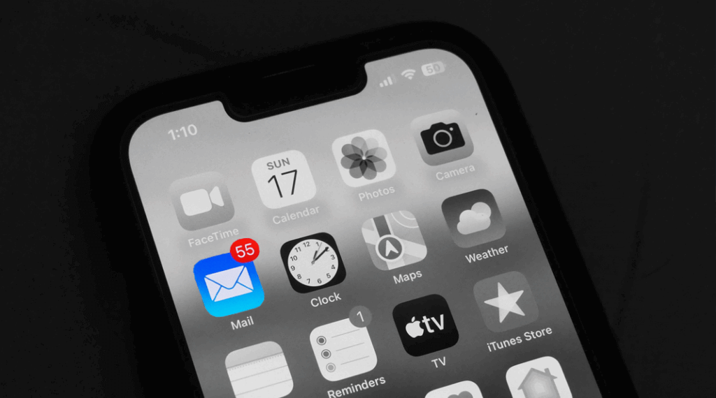 Un téléphone en noir et blanc où seule l'appli de messagerie est en couleur et indique 55 messages non lus